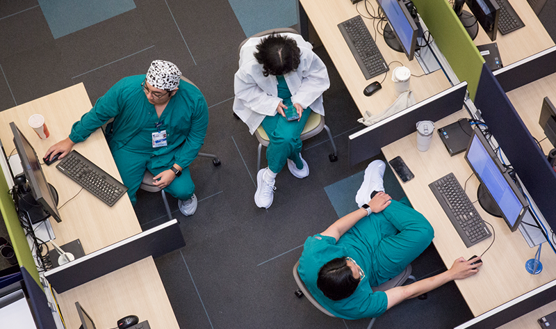 Medical personnel at desks in front of computers