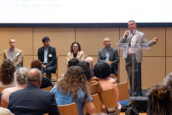David Hasan speaks at a microphone