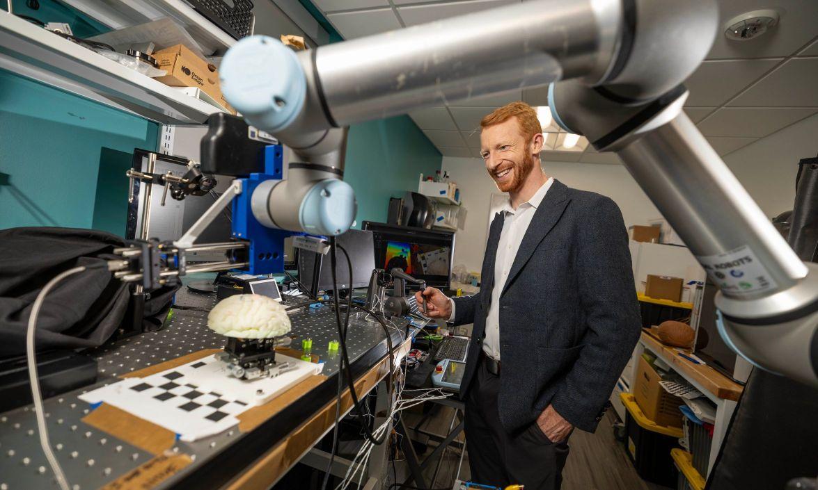 Patrick Codd, MD, works with a robot in the lab. 