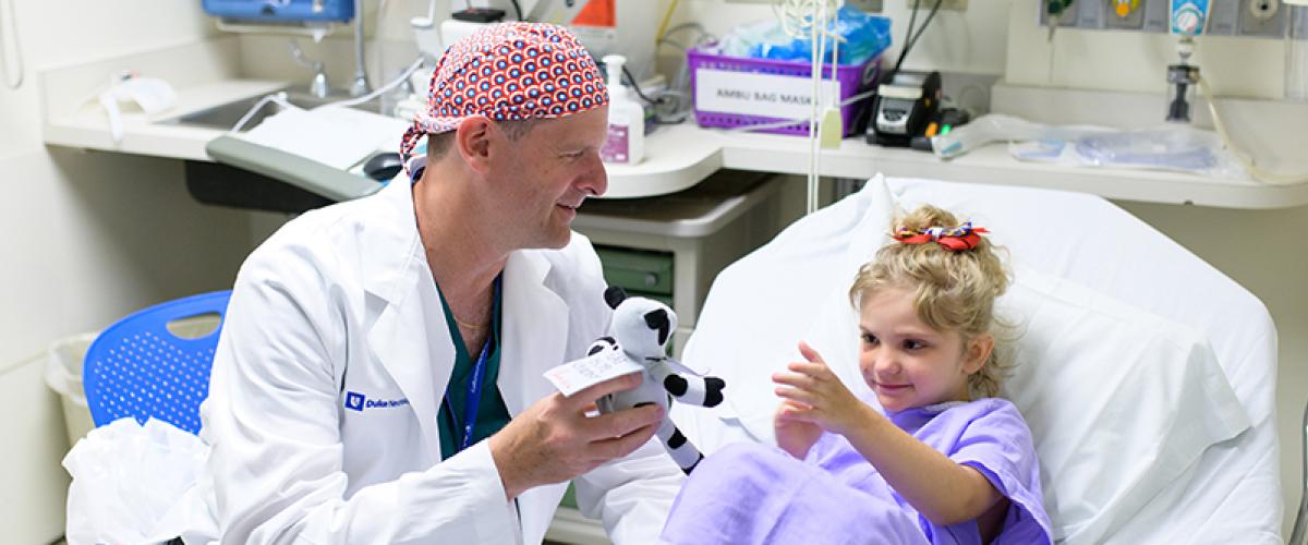 Dr. Grant talks to a young patient in pre-op