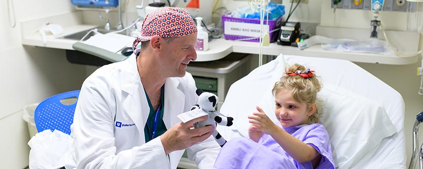 Dr. Grant talks to a young patient in pre-op